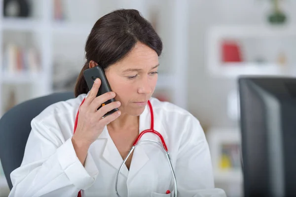 Mladý ženský lékař mluví na mobilním telefonu — Stock fotografie