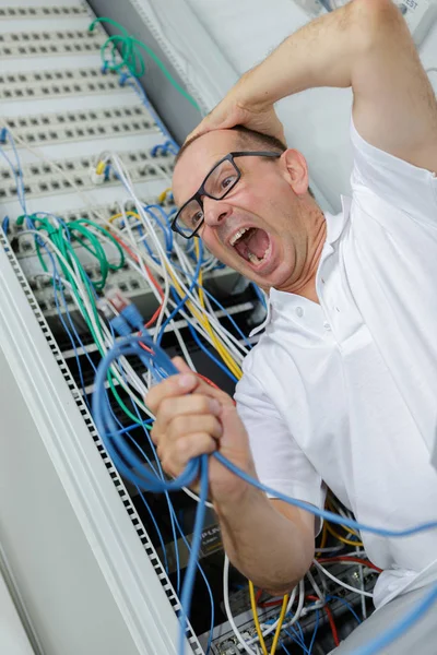 Hombre enojado y confundido usando cables equivocados — Foto de Stock