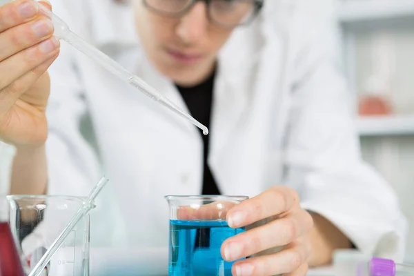 Hombre sosteniendo y magra un vaso cayendo pipet — Foto de Stock