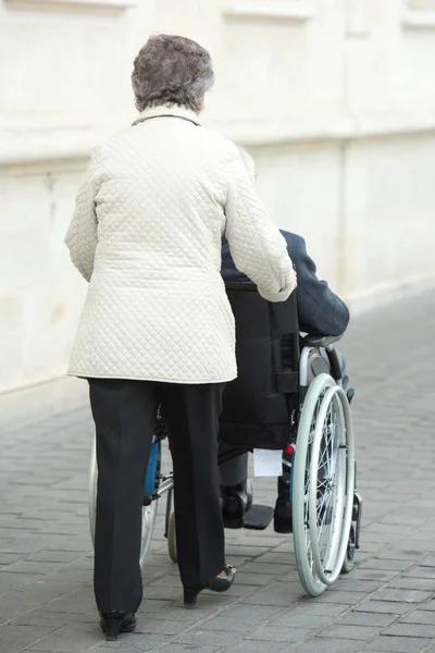 Пара в инвалидной коляске на открытом воздухе — стоковое фото