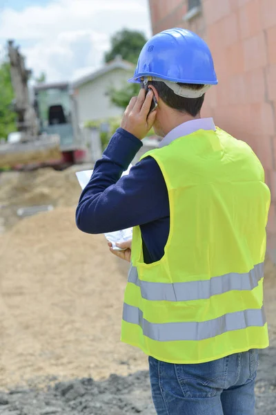 Builder in helmet with clipboard outdoors — Stock Photo, Image