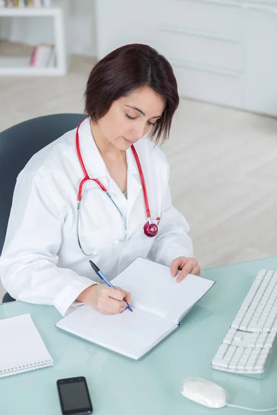 Woman doctor writes prescription — Stock Photo, Image