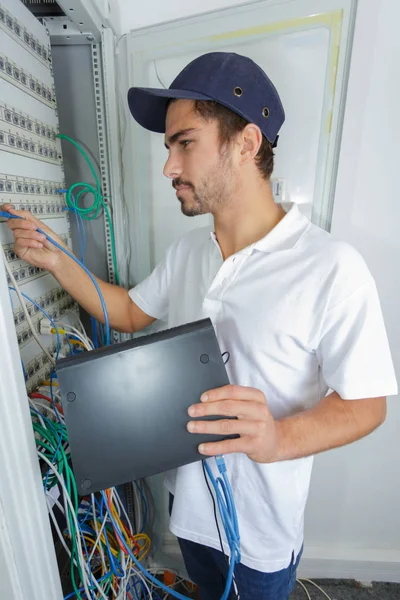 Electrician connect internet server to the power board — Stock Photo, Image