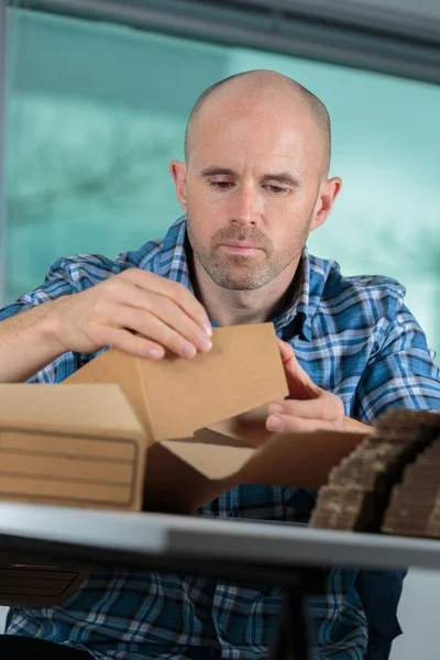 Uomo che assembla cartone e uomo — Foto Stock