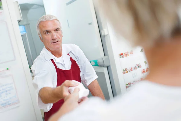 Slaktaren servering kund och förkläde — Stockfoto