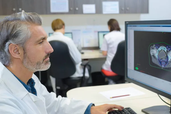 Médico sênior estudando imagem na tela — Fotografia de Stock