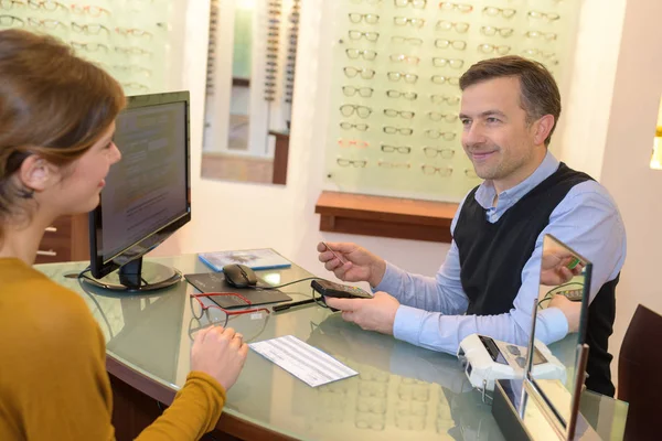 Optician e cliente sentaram-se na mesa — Fotografia de Stock