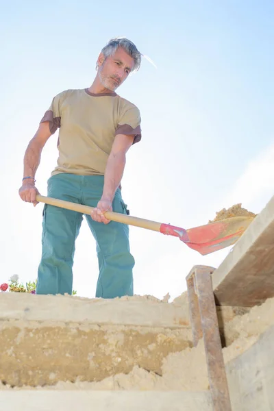 Bauarbeiter steckt Sand in ein Loch — Stockfoto