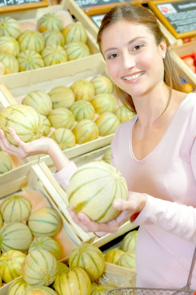 Jovem mulher escolher cantaloup — Fotografia de Stock