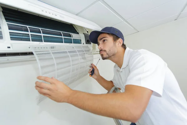 Porträtt av mitten av vuxna manliga tekniker reparera luftkonditioneringen — Stockfoto