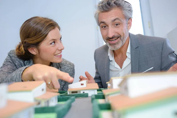 Homem e mulher olhando para casas modelo — Fotografia de Stock
