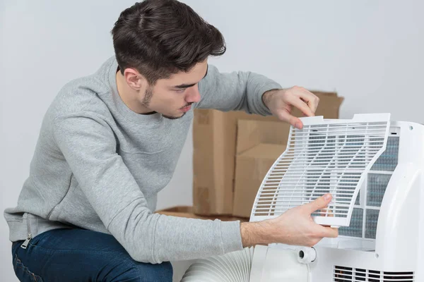 Bonito jovem eletricista instalar ar condicionado na casa do cliente — Fotografia de Stock