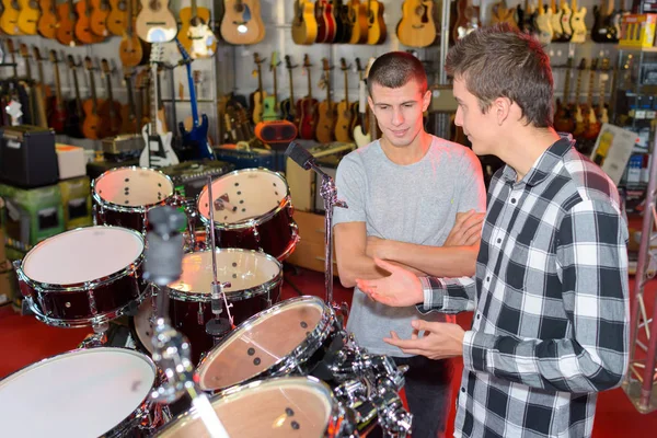 Dois jovens olhando para estacas de tambor em uma loja — Fotografia de Stock