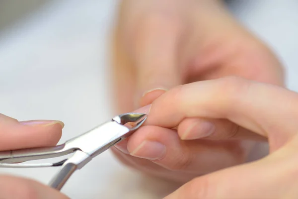 Pincet wordt gebruikt op een vrouw s vingernagel — Stockfoto