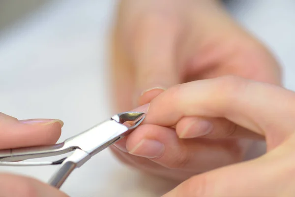 Pinzas que se utilizan en la uña de una mujer — Foto de Stock