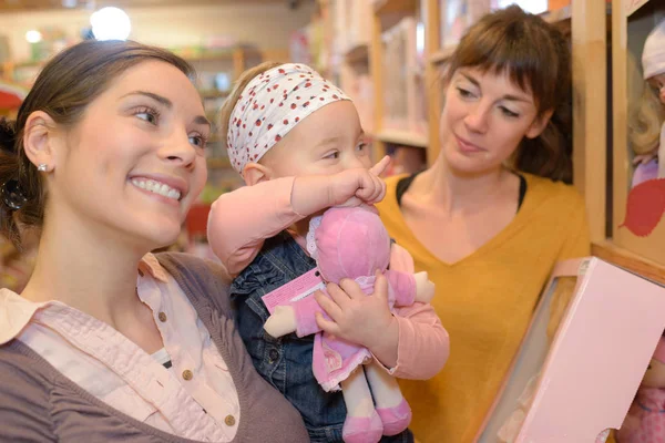 Mère et fille avec vendeur attrayant dans le magasin de jouets — Photo