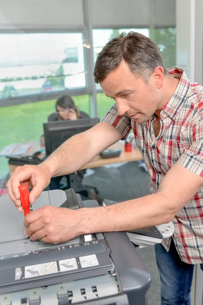 Homem que repara fotcopiadora e copiadora — Fotografia de Stock