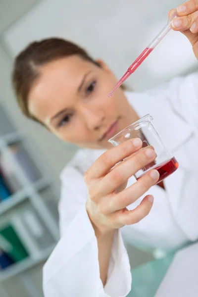 Женщина, работающая с пробирками крови в лаборатории — стоковое фото