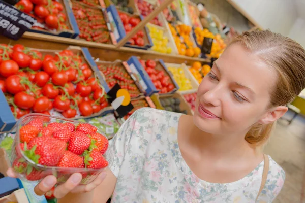 Mujer rubia eligiendo algunas fresas Imagen De Stock