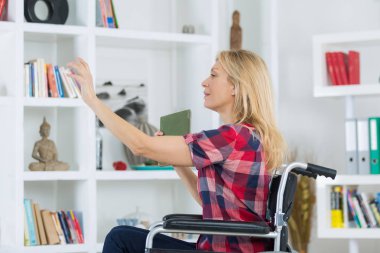 Disabled woman reaching book from shelf clipart