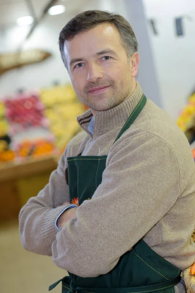Portret van een knappe verkoper met armen gekruist in supermarkt — Stockfoto