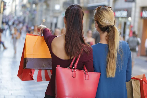 Unga glada och förmögna kvinnor shopping — Stockfoto