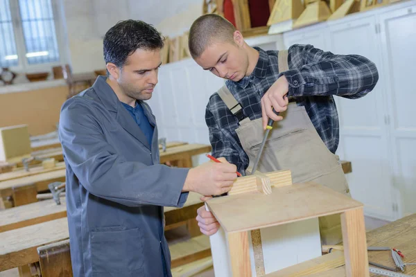 Ученик плотника с инструктором — стоковое фото