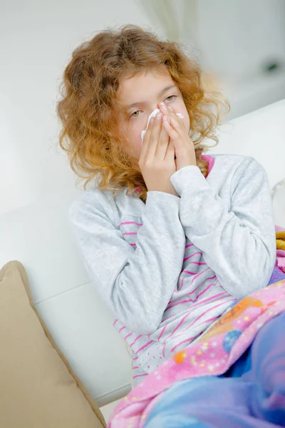Sjuka lilla flickan blåser näsan — Stockfoto