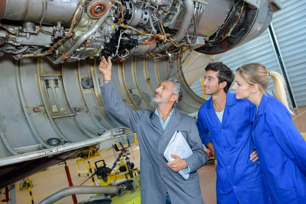 Hombre con dos jóvenes mirando el fuselaje —  Fotos de Stock