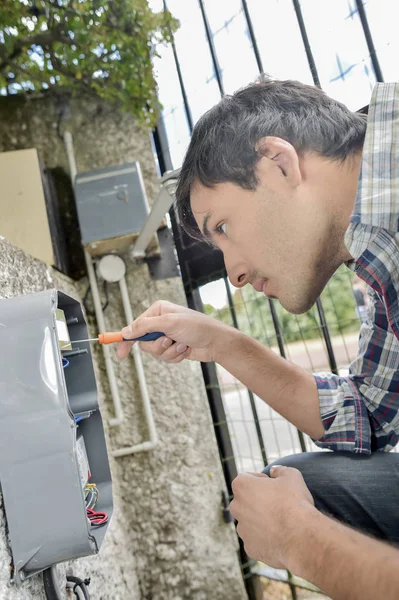 Elettricista che ripara un sistema di interfono — Foto Stock