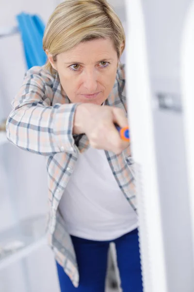 Blonde Heimwerkerin putzt Lüftungsanlage — Stockfoto