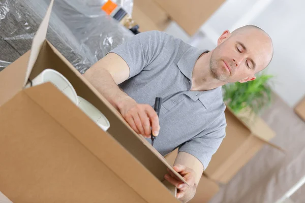 Jovem homem embalagem caixas — Fotografia de Stock