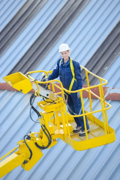 Vrouw in de kooi hoogwerker — Stockfoto