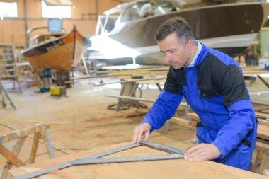 shipwright measuring the plywood clipart