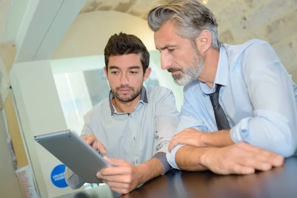 Företagsledare och medarbetare med digital tablet i office — Stockfoto