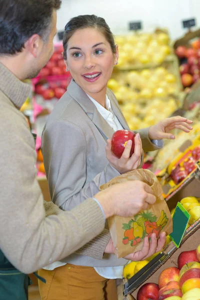 Mujer comprando manzanas, hablando con el tendero —  Fotos de Stock