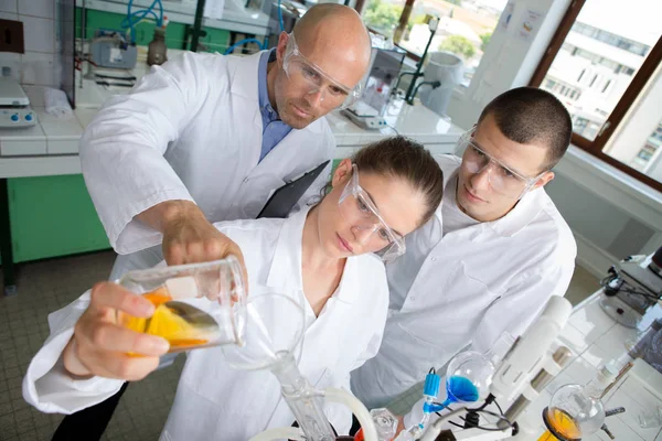 De wetenschap van het leven van de jonge professionele pipetting oplossing in de glas-cuvette — Stockfoto