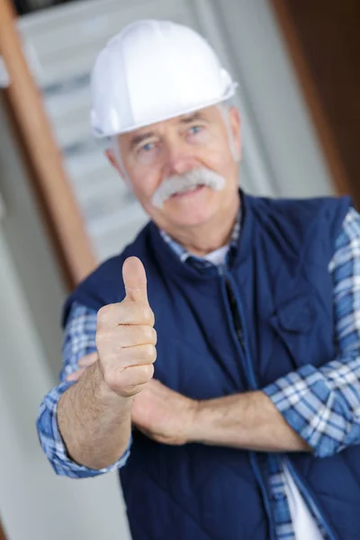 Alter Mann mit Helm reckt Daumen hoch — Stockfoto