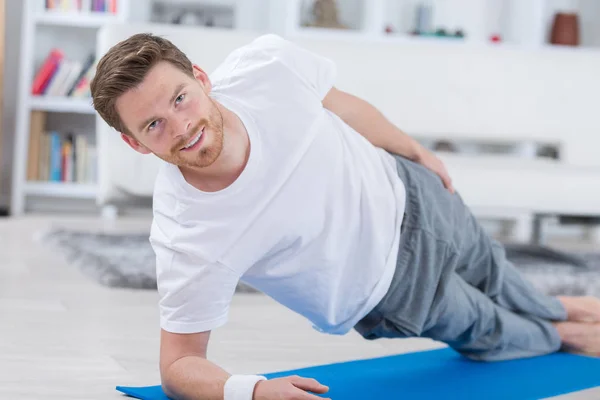 Yoga adam idoing fitness mavi mat — Stok fotoğraf