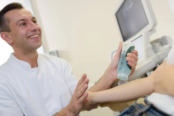 Médico poniendo gel en el brazo de los pacientes antes del ultrasonido —  Fotos de Stock