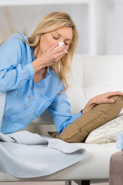 Wanita senior menutupi hidung sambil bersin di kamar tidur di rumah — Stok Foto