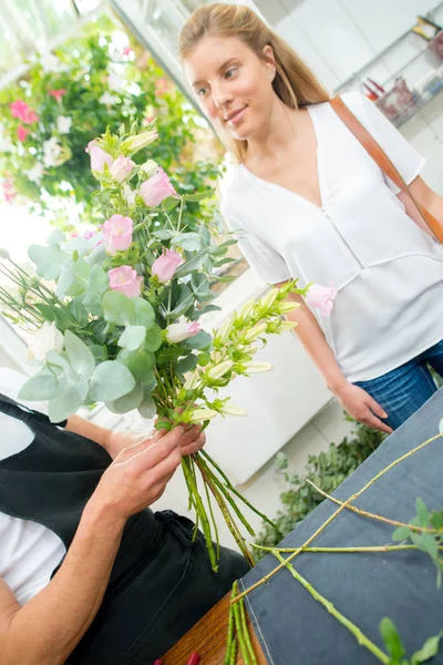 Клиент и цветы и фартук — стоковое фото