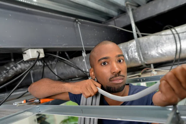 Trabajador joven conectando cables — Foto de Stock