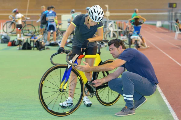 Cyklist och instruktör tittar på cykel — Stockfoto