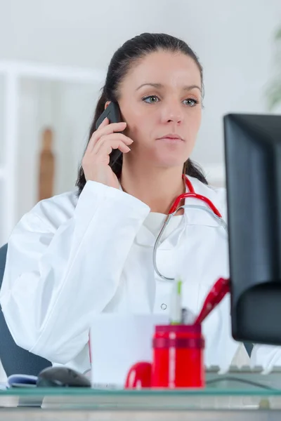 Läkare sitta vid skrivbordet och skriva — Stockfoto