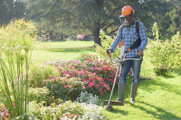 Man met behulp van een gras-trimmer — Stockfoto