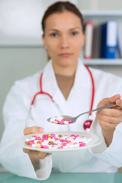 Different diet pills in white plate and female hands — Stock Photo, Image