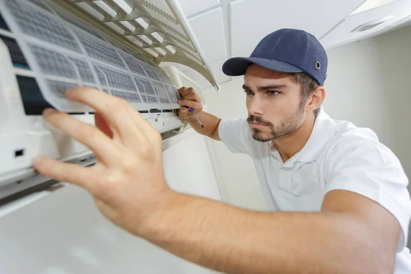 Porträtt av mitten av vuxna manliga tekniker reparera luftkonditioneringen — Stockfoto