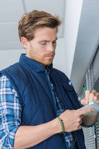 Tradesman taking notes by window