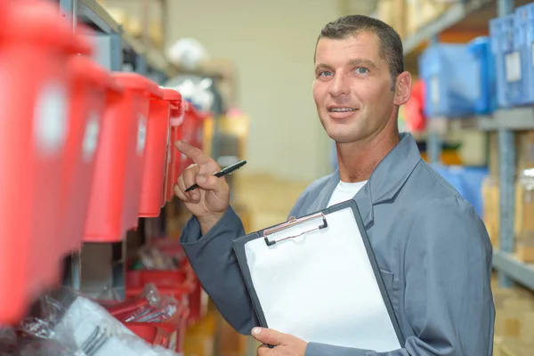 Man in magazijn wijzen naar container — Stockfoto